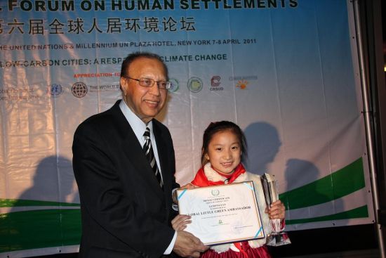 李泓燕荣获“全球绿色环保儿童大使”称号，第六届全球人居环境论坛主席、联合国副秘书长乔杜里为其颁奖。