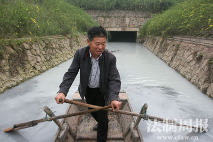 武汉南太子湖渔民万志友驾船带着环保人士在排污渠调查“牛奶河”污染问题。