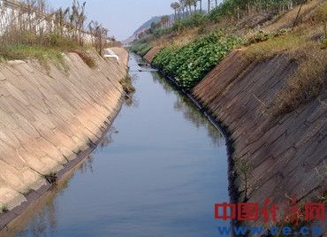 九钢新厂区排出的强碱性污水顺着金砂湾工业城南面的一条排污明渠流淌，一直排入长江。