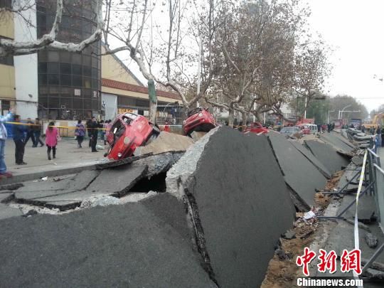 在距离青岛爆燃事故爆炸中心现场1公里外的青岛市黄岛区斋堂岛街，受爆炸冲击的街道露出了20多厘米厚的混凝土路面，似揭开的鱼鳞，路边躺着十余辆侧翻的汽车。 黄品璇 摄