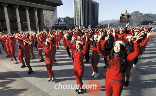 28日下午，在首尔光化门广场上，首尔综合艺术学校的350名学生身穿红色内衣正在跳舞。他们伴随2014年仁川亚运会主题歌跳1个小时的舞蹈，呼吁将仁川亚运会打造成“低碳环保大会”。（韩国《朝鲜日报》网站截图） 