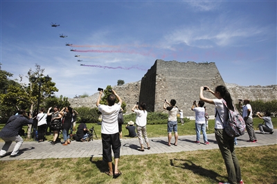 9月3日，明城墙遗址公园，市民在观看空中梯队飞越北京上空。新京报记者 浦峰 摄