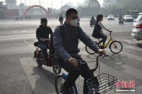 北京迎来沙尘天气市区能见度降低，市民佩戴口罩出行。 中新网记者 金硕 摄