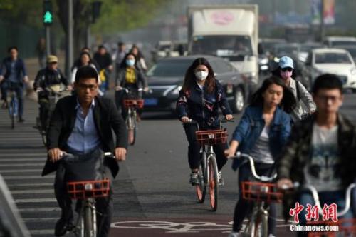 北京迎来沙尘天气市区能见度降低，市民佩戴口罩出行。 中新网记者 金硕 摄