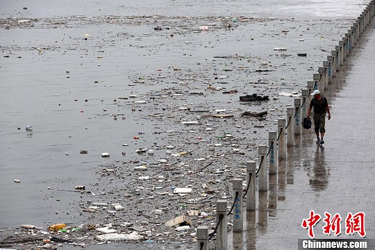 资料图：山西太原遭遇暴雨袭击，雨水将大量垃圾冲入汾河公园河道内，致使河面漂浮大面积垃圾，造成河水污染。中新社发 武俊杰 摄