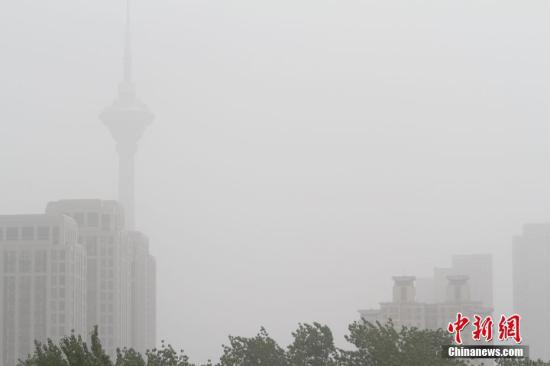 资料图为天津地标建筑之一的“天塔”在沙尘中若隐若现。 中新社记者 张道正 摄